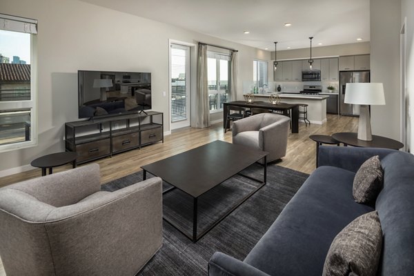 Living room featuring modern decor and large windows at AV8 Apartments, a luxury Greystar property in the city center
