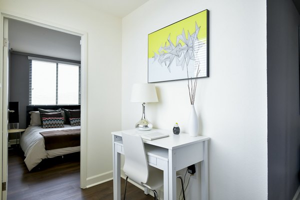 Bedroom with elegant furnishings at The Fillmore Center Apartments, featuring modern design and ample natural light