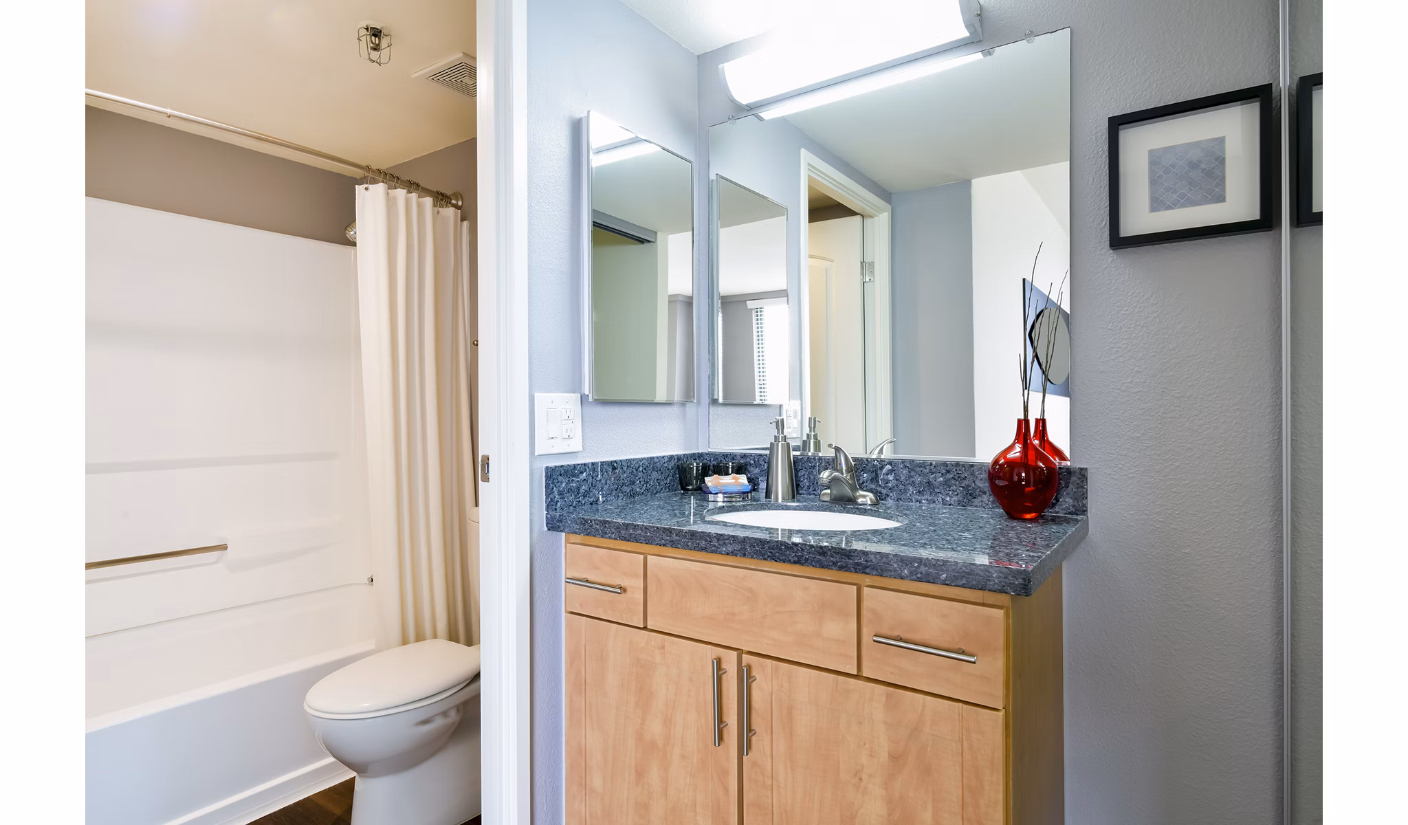 Bathroom with modern fixtures at The Fillmore Center Apartments, featuring sleek countertops and contemporary lighting