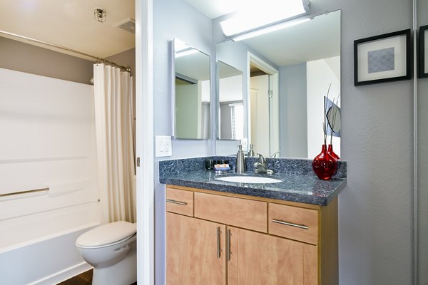 Bathroom with modern fixtures at The Fillmore Center Apartments, featuring sleek countertops and contemporary lighting