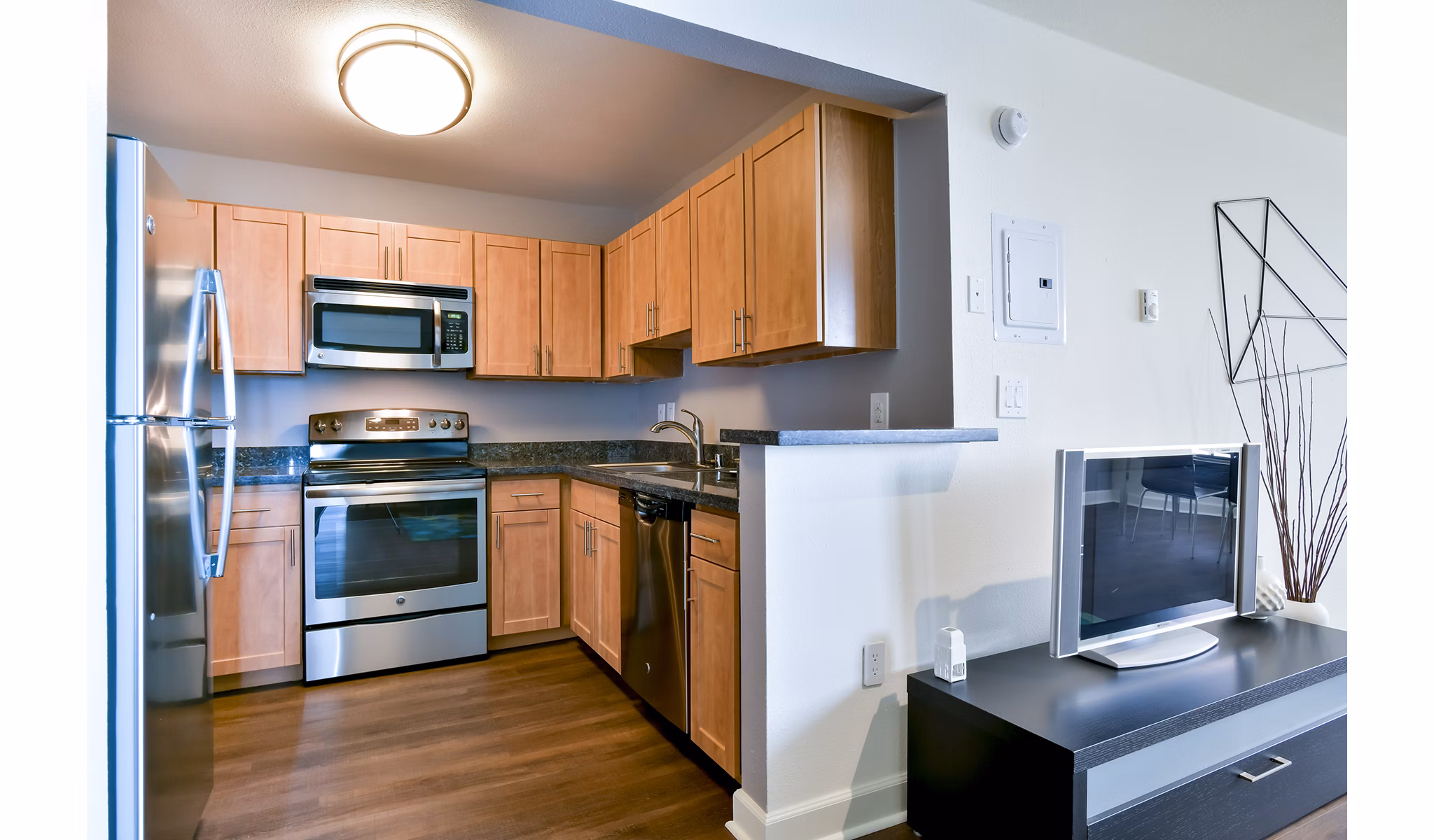 Modern kitchen featuring stainless steel appliances and granite countertops at The Fillmore Center Apartments