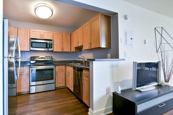 Modern kitchen featuring stainless steel appliances and granite countertops at The Fillmore Center Apartments