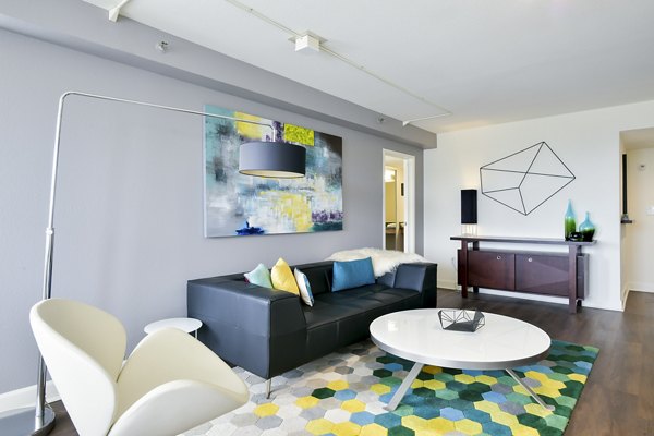 Living room with modern decor and ample natural light at The Fillmore Center Apartments