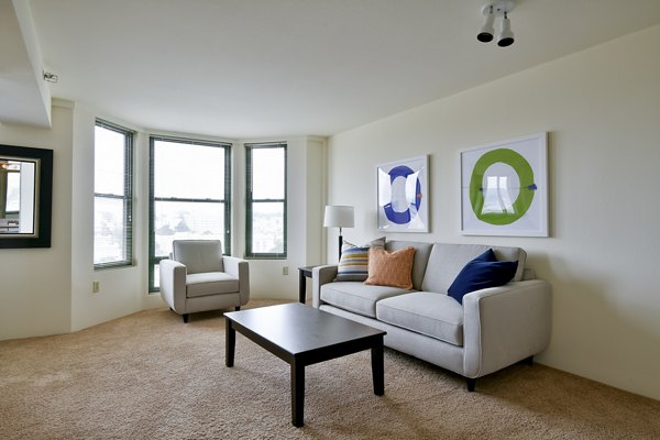 Spacious living room with modern decor and large windows in The Fillmore Center Apartments