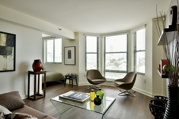 Spacious living room with modern furniture and large windows in The Fillmore Center Apartments