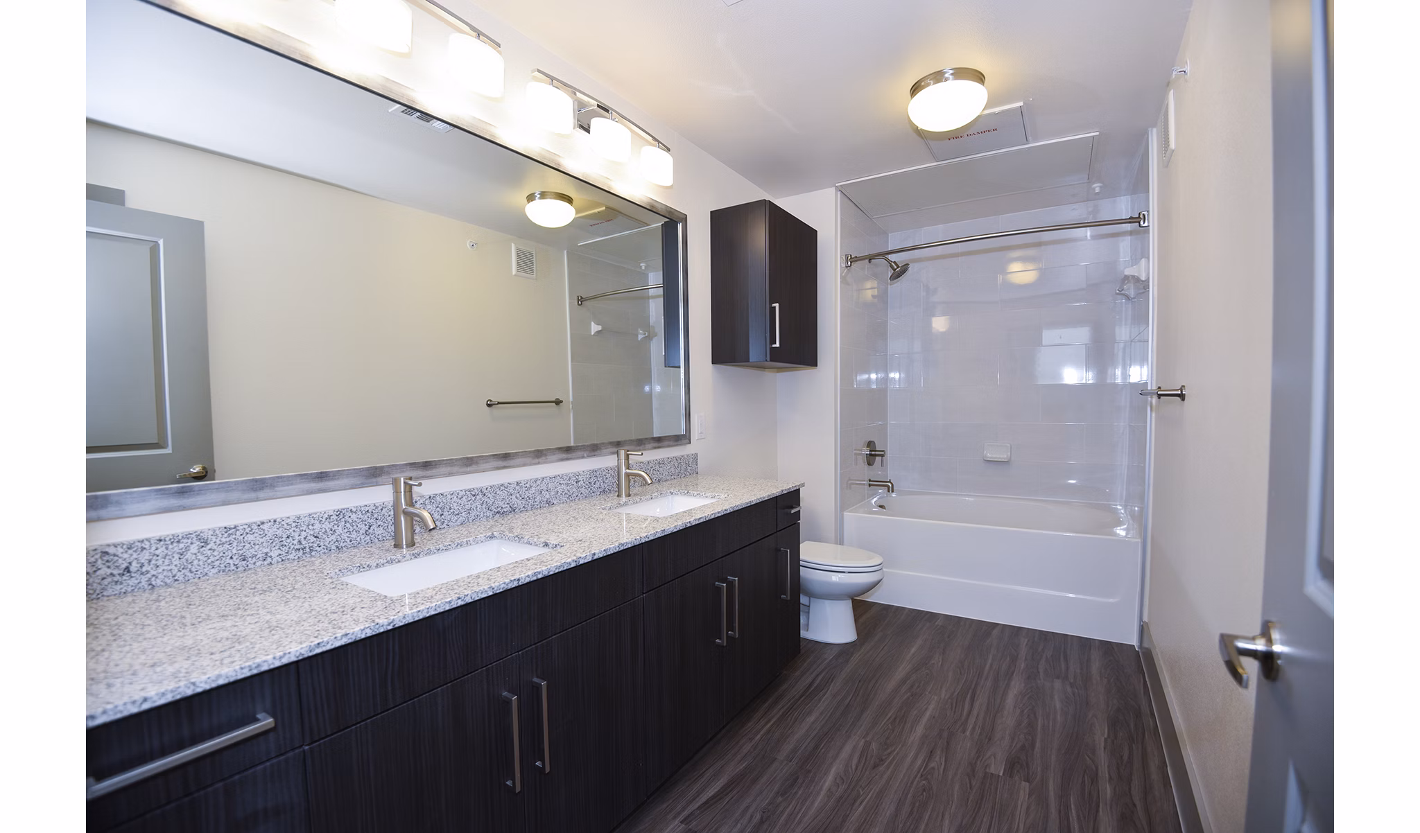 Modern bathroom with sleek fixtures and large mirror at Encore Montrose Apartments, offering luxurious living spaces