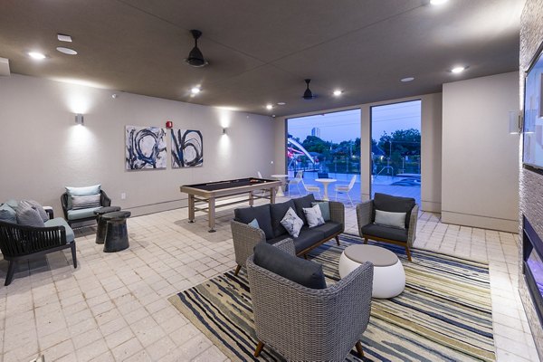 Game room featuring billiards and arcade games at Encore Montrose Apartments