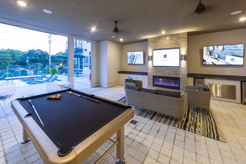 Game room with billiards table and lounge area at Encore Montrose Apartments