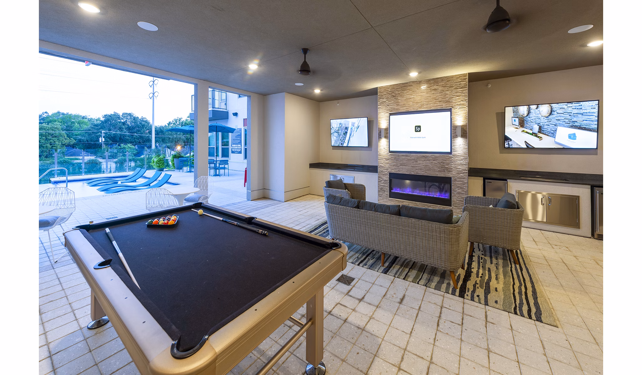 Game room with billiards table and lounge area at Encore Montrose Apartments