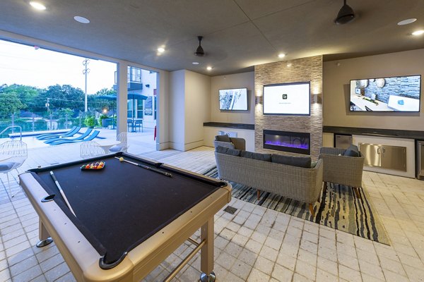 Game room with billiards table and lounge area at Encore Montrose Apartments