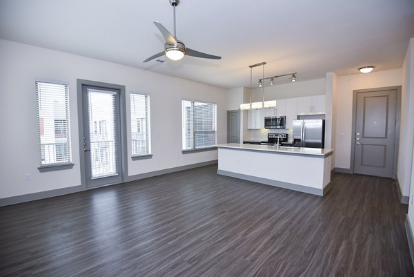 Inviting living room with modern decor and large windows at Encore Montrose Apartments, a luxury community in the heart of the city
