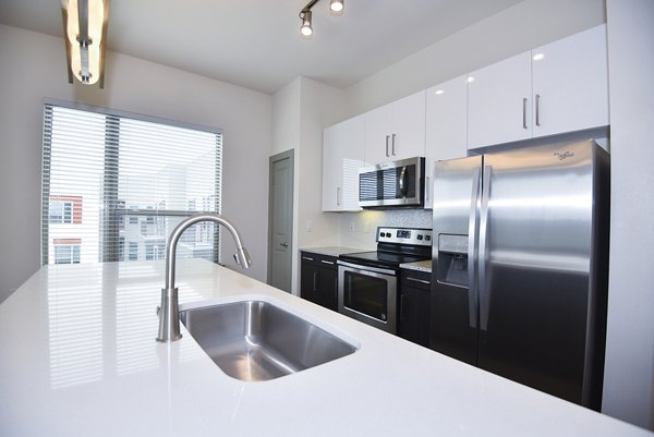 Modern kitchen with stainless steel appliances in Encore Montrose Apartments
