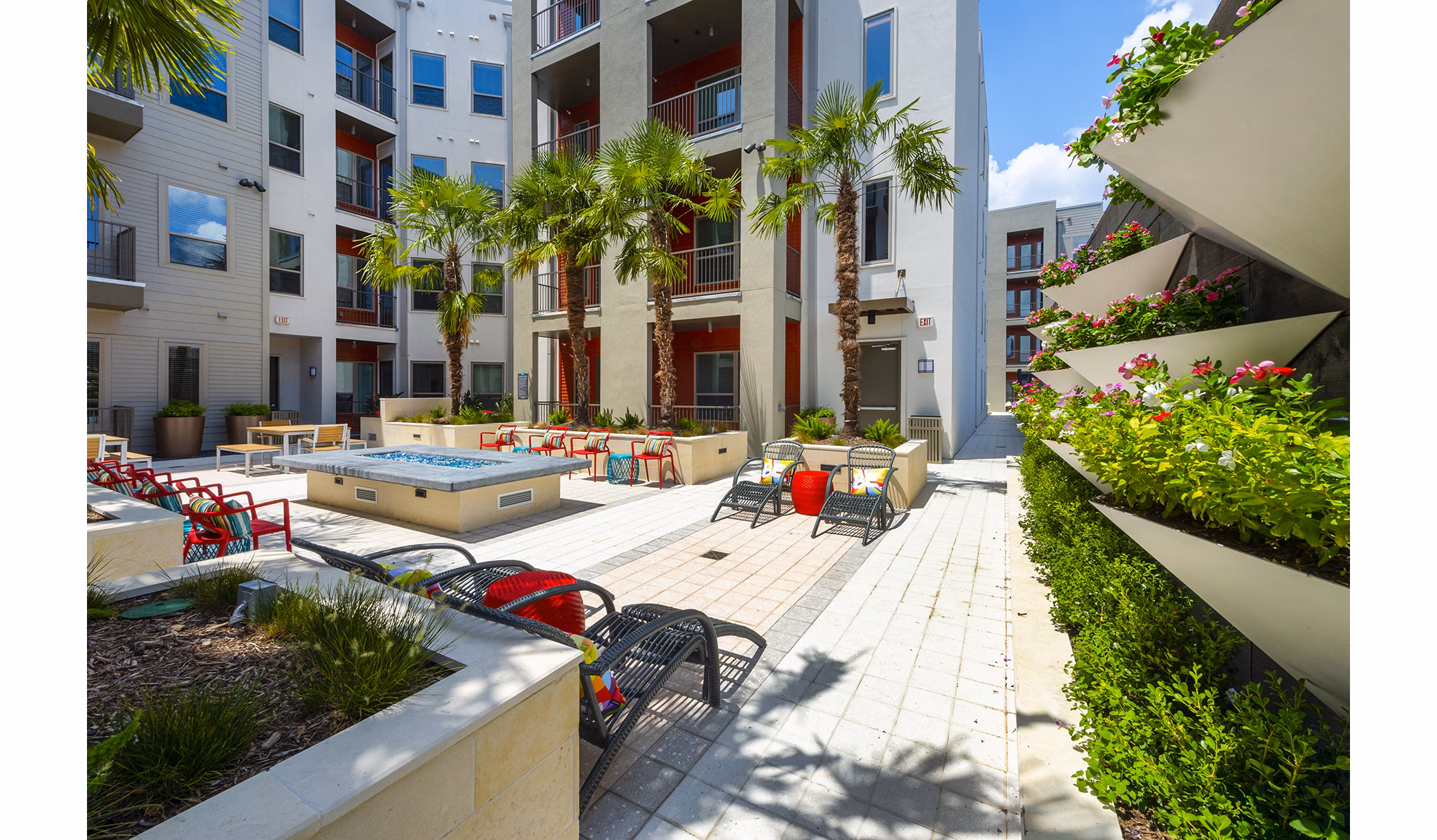 Fire pit lounge area at Encore Montrose Apartments featuring cozy seating and ambient lighting for relaxing evenings