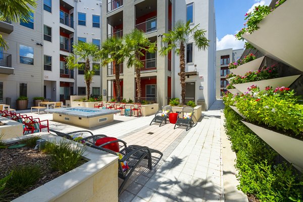 Fire pit lounge area at Encore Montrose Apartments featuring cozy seating and ambient lighting for relaxing evenings