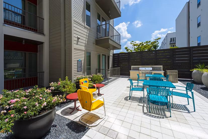 Outdoor grill area with modern seating at Encore Montrose Apartments, offering a perfect spot for gathering and entertaining
