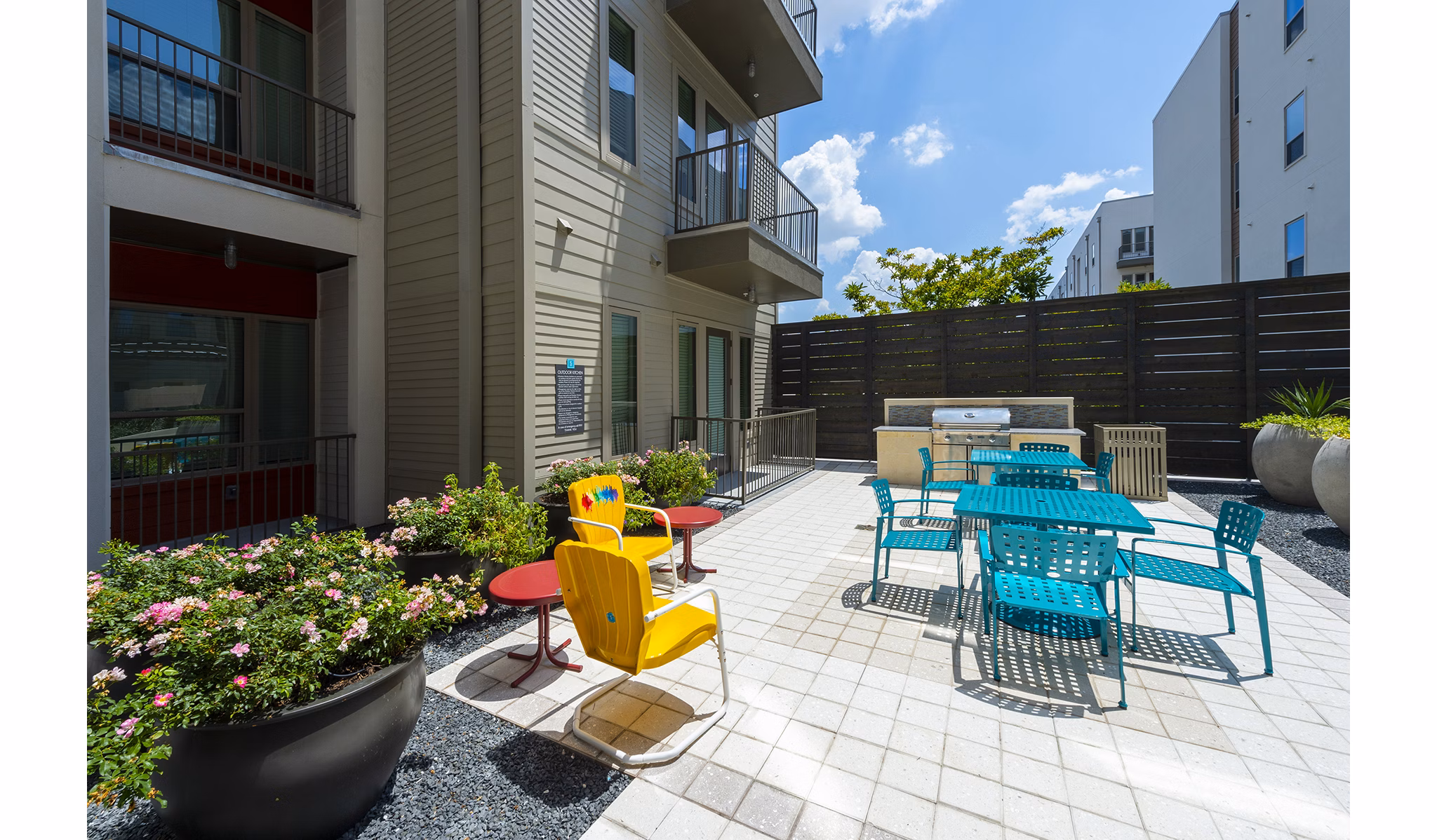 Outdoor grill area with modern seating at Encore Montrose Apartments, offering a perfect spot for gathering and entertaining