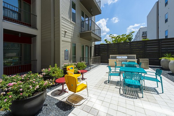 Outdoor grill area with modern seating at Encore Montrose Apartments, offering a perfect spot for gathering and entertaining