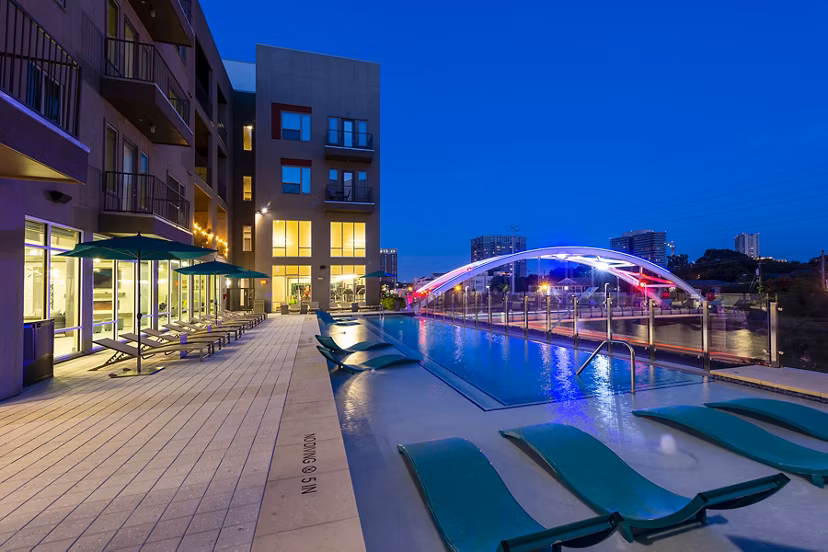 Resort-style pool with lounge chairs at Encore Montrose Apartments, offering luxury living in a vibrant community