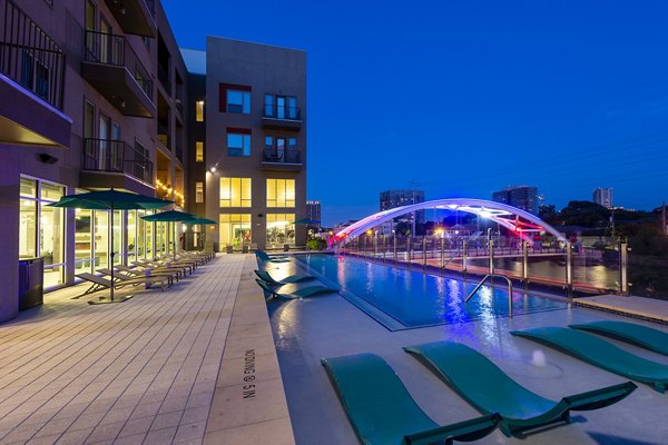 Resort-style pool with lounge chairs at Encore Montrose Apartments, offering luxury living in a vibrant community