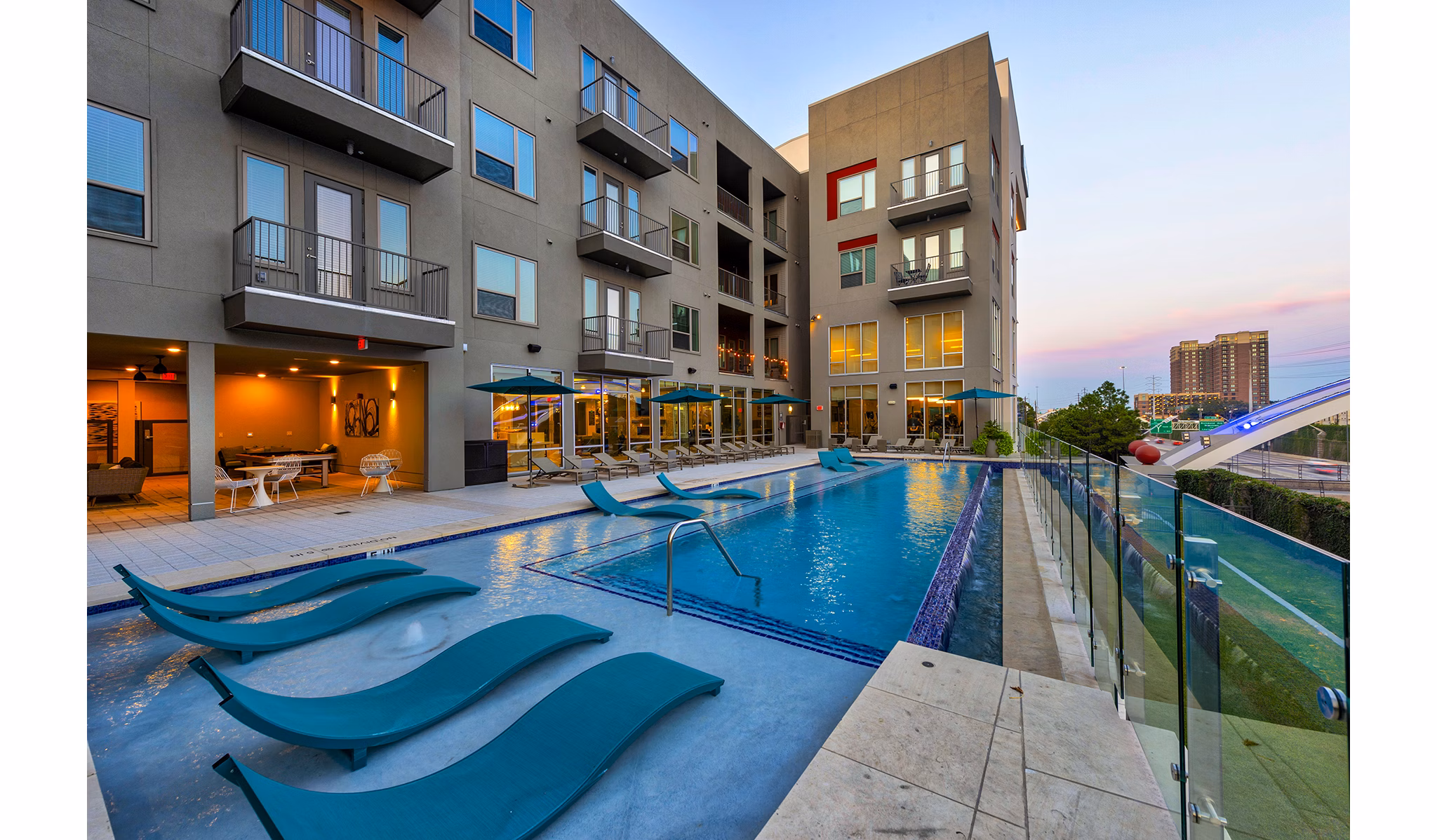 Stylish outdoor pool with sun loungers at Encore Montrose Apartments
