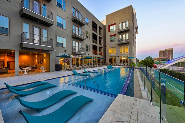 Stylish outdoor pool with sun loungers at Encore Montrose Apartments