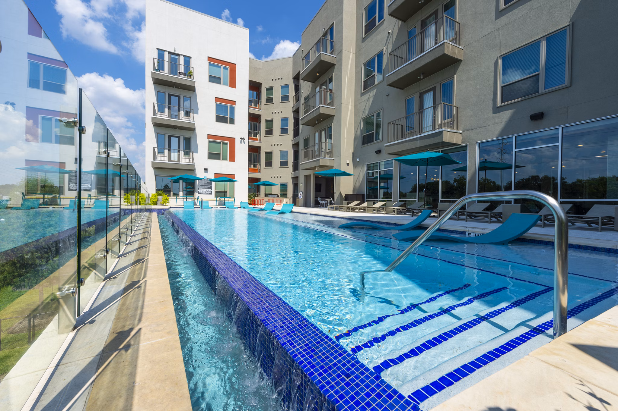Luxury poolside ambiance at Encore Montrose Apartments with sleek lounge chairs and modern design in vibrant urban surroundings