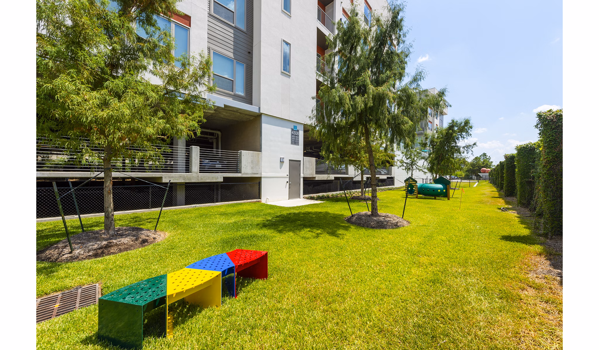Modern dog park with agility equipment at Encore Montrose Apartments, perfect for pet-friendly living