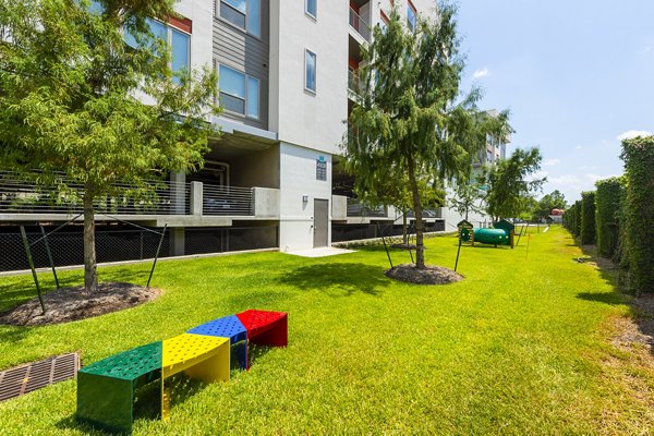 Modern dog park with agility equipment at Encore Montrose Apartments, perfect for pet-friendly living