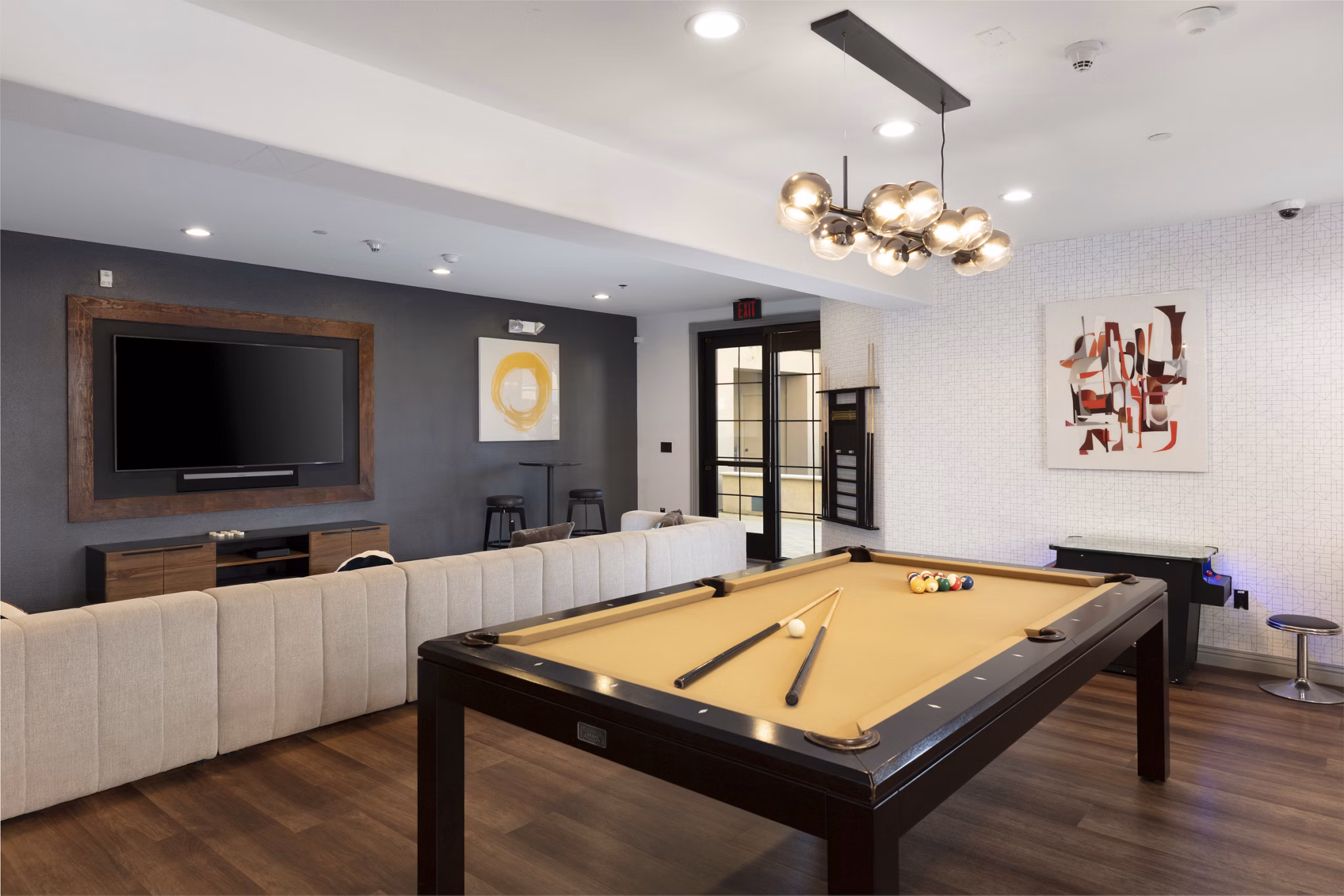Modern game room with a pool table and wall-mounted TV in luxury apartments