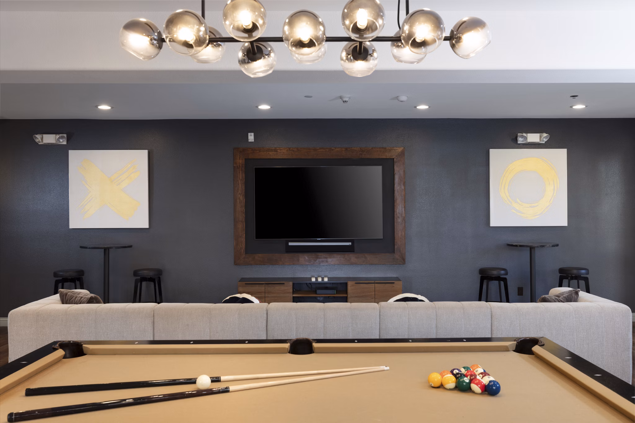 Game room with pool table and lounge chairs at Aventino Apartments