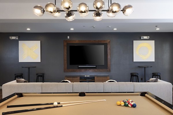 Game room with pool table and lounge chairs at Aventino Apartments