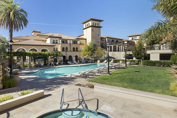 Aventino Apartments: Luxurious pool area with lounge chairs and umbrellas, perfect for relaxing in the sun