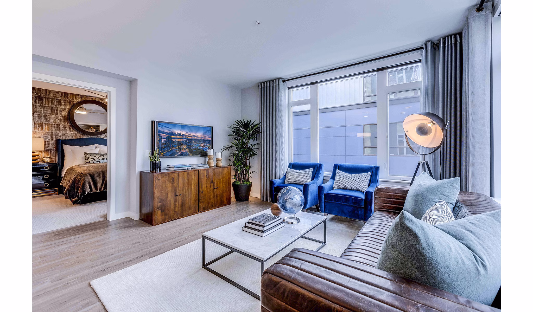 Modern living room with chic furniture and large windows at Marlowe Apartments