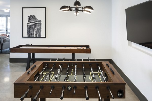 Modern game room with billiards table and neon accents at Alexan LoHi Apartments