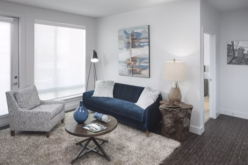Living room with modern decor and natural light at Alexan LoHi Apartments, luxury apartments by Greystar in Denver