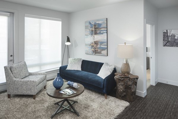 Living room with modern decor and natural light at Alexan LoHi Apartments, luxury apartments by Greystar in Denver