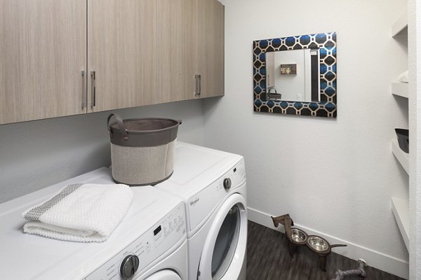 Spacious laundry room with modern appliances in Alexan LoHi Apartments, offering convenience for residents