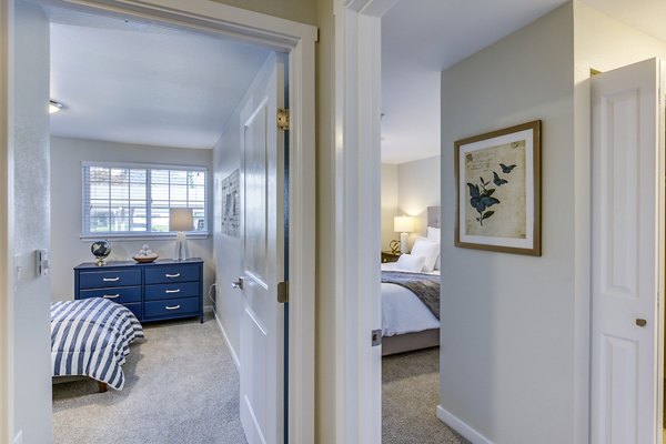 Modern hallway leading to a cozy bedroom at Callen Apartments with stylish lighting and neutral tones