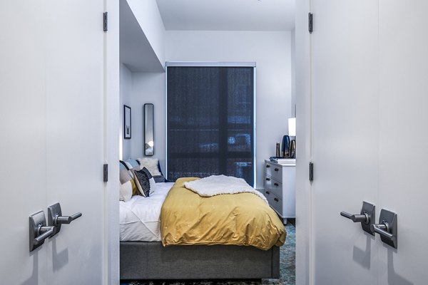 Elegant bedroom with modern decor and natural light at Hyde Square Apartments