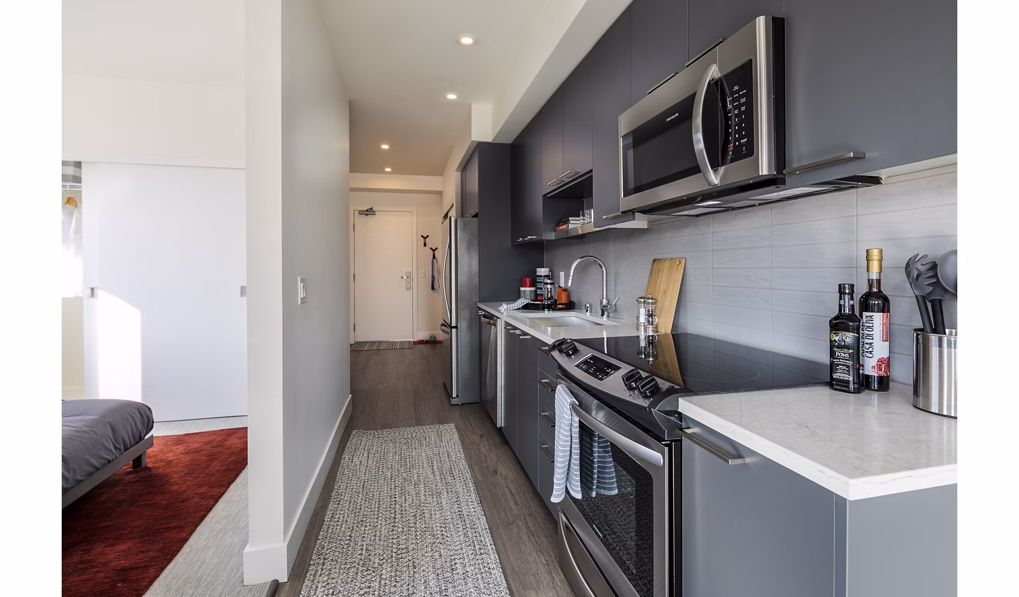 Modern kitchen featuring stainless steel appliances and granite countertops in Hyde Square Apartments