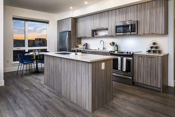 Modern kitchen with granite countertops and stainless steel appliances at Hyde Square Apartments