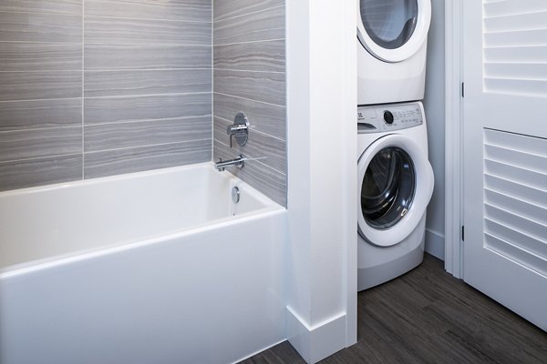 Laundry room with modern appliances at Hyde Square Apartments in Bellevue
