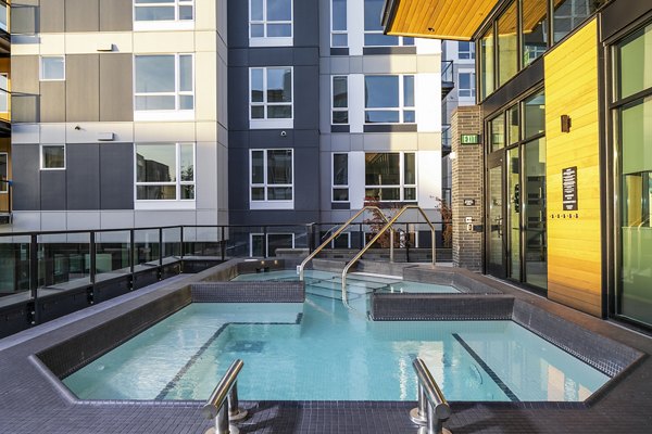 Outdoor pool with stylish seating at Hyde Square Apartments