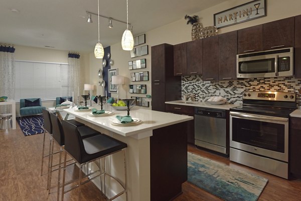 Modern kitchen featuring stainless steel appliances and granite countertops in Station 650 Apartments