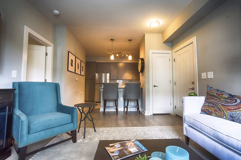 Living room with modern furnishings and large windows at Marlowe Lake Boone Apartments