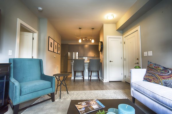 Living room with modern furnishings and large windows at Marlowe Lake Boone Apartments