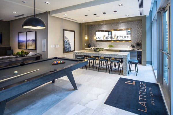 Game room featuring a pool table, bar seating, and kitchenette at Latitude luxury apartments