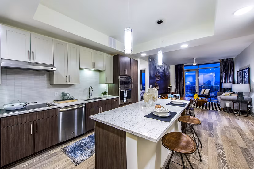 Modern kitchen with stainless steel appliances and granite countertops in Latitude Med Center Apartments, ideal for luxury living in a vibrant community