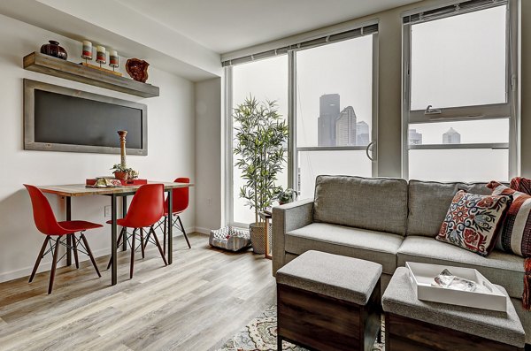 Spacious living room featuring modern decor and ample natural light in Zig Apartments