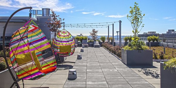 Rooftop patio with seating and skyline views at Zig Apartments, a luxurious property by Greystar